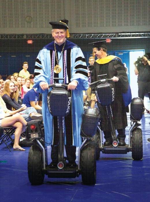 President Thomas J. Haas and Dean Kamen ride Segways out of the Fieldhouse after convocation August 28. Kamen received an honorary degree.